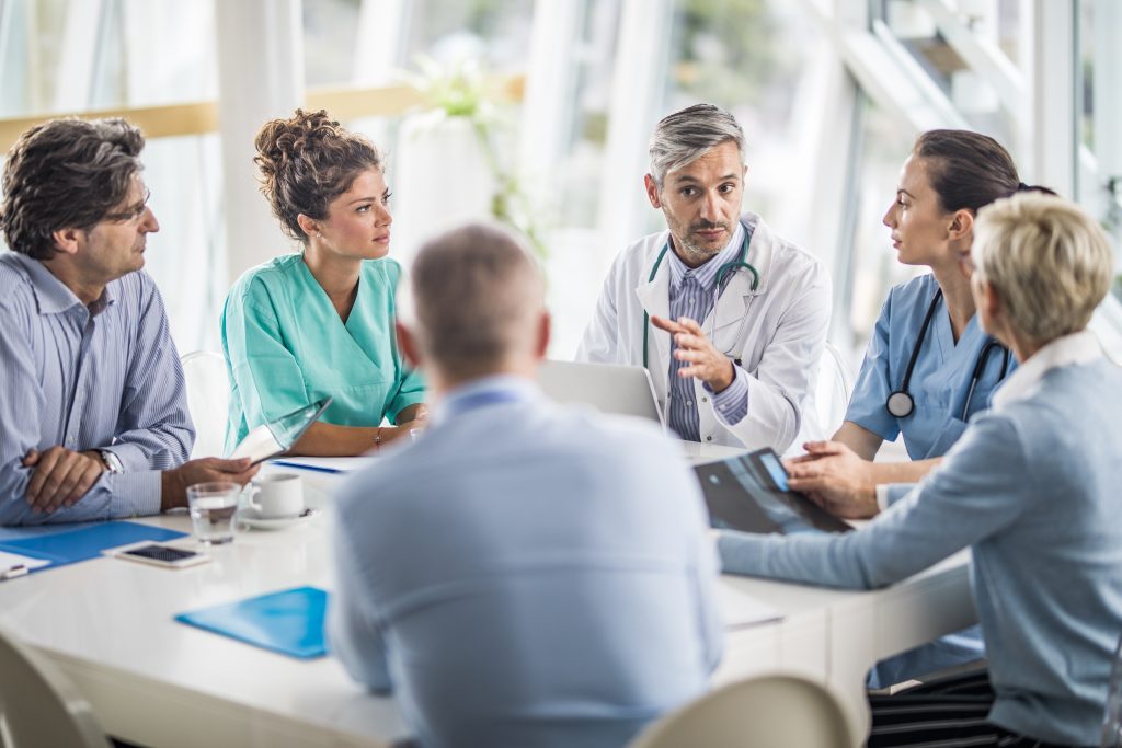 Team of doctors and business people talking on a meeting at doctor's office.